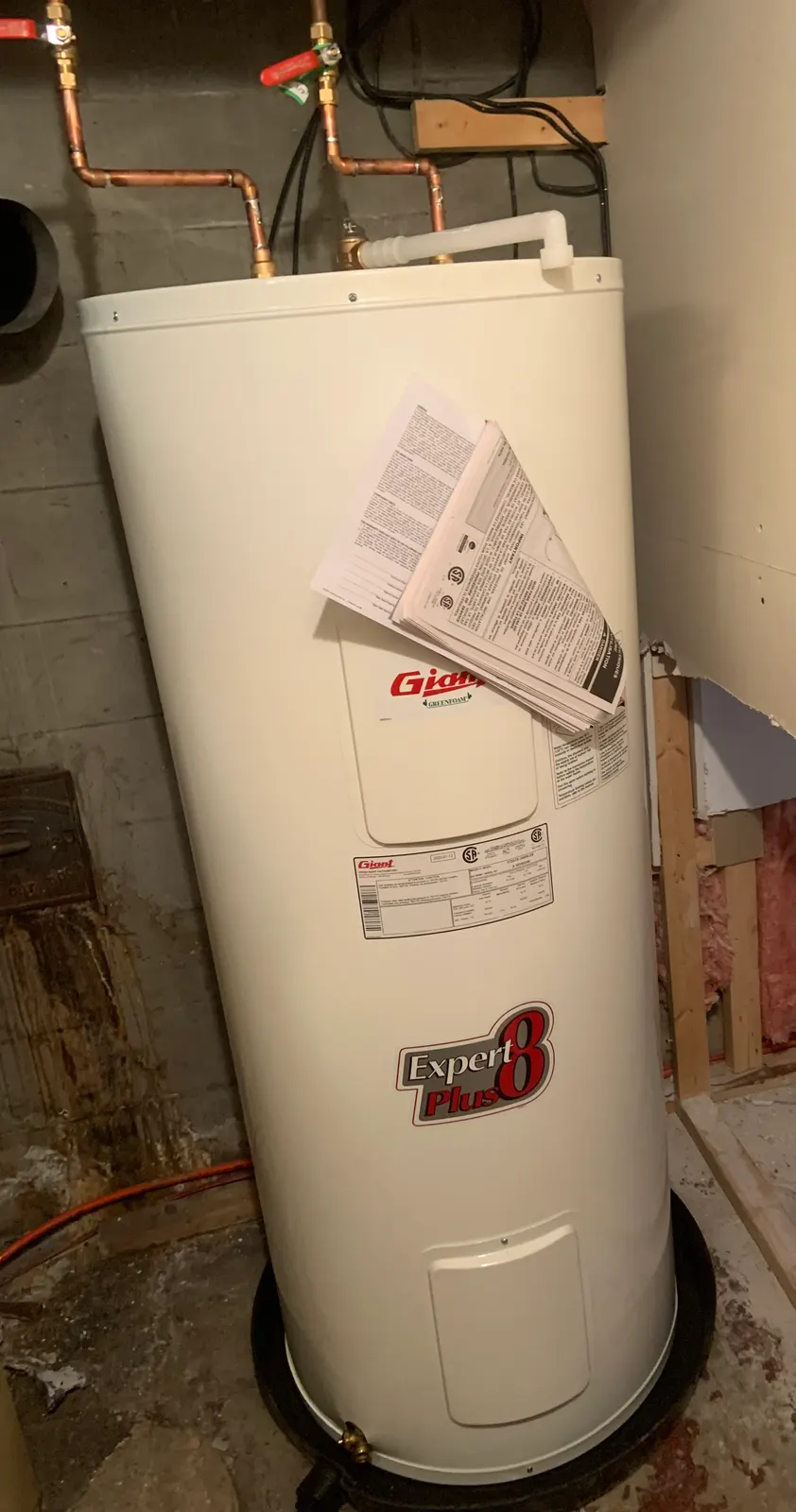 New electric water heater set in a drain pan and connected in copper.