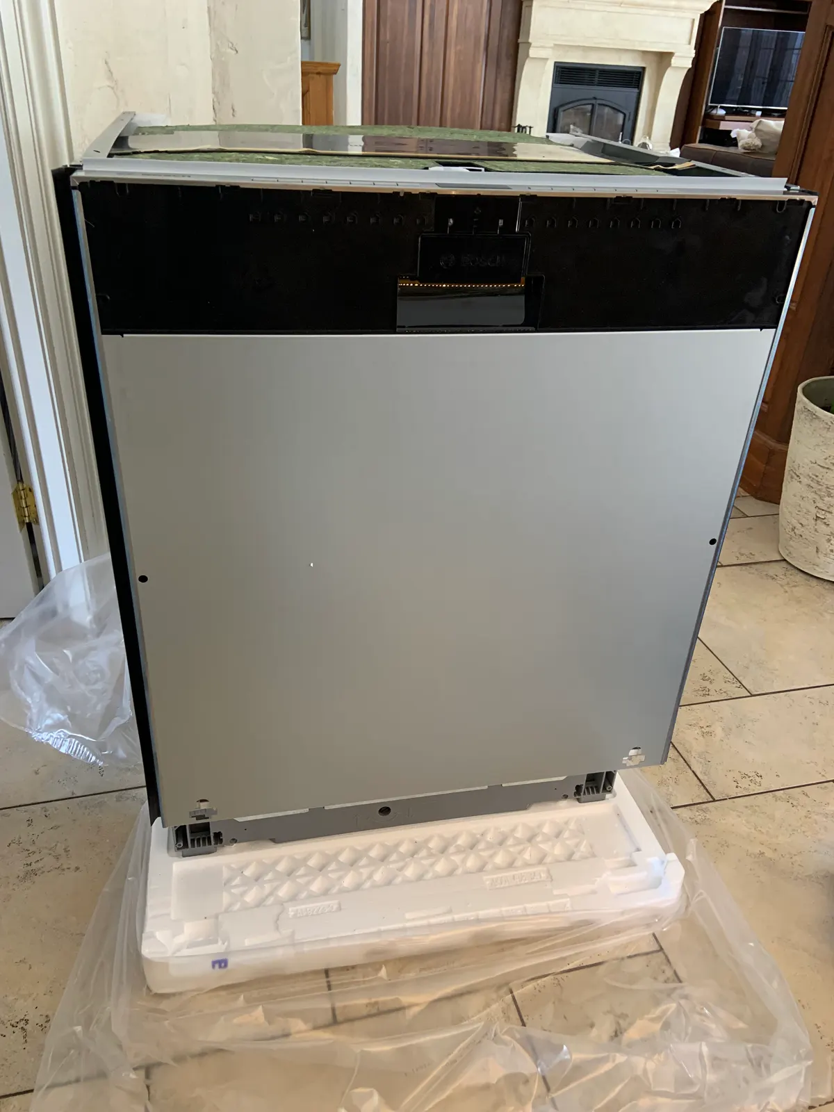 New built-in dishwasher unpacked on its protective base, ready to be installed.
