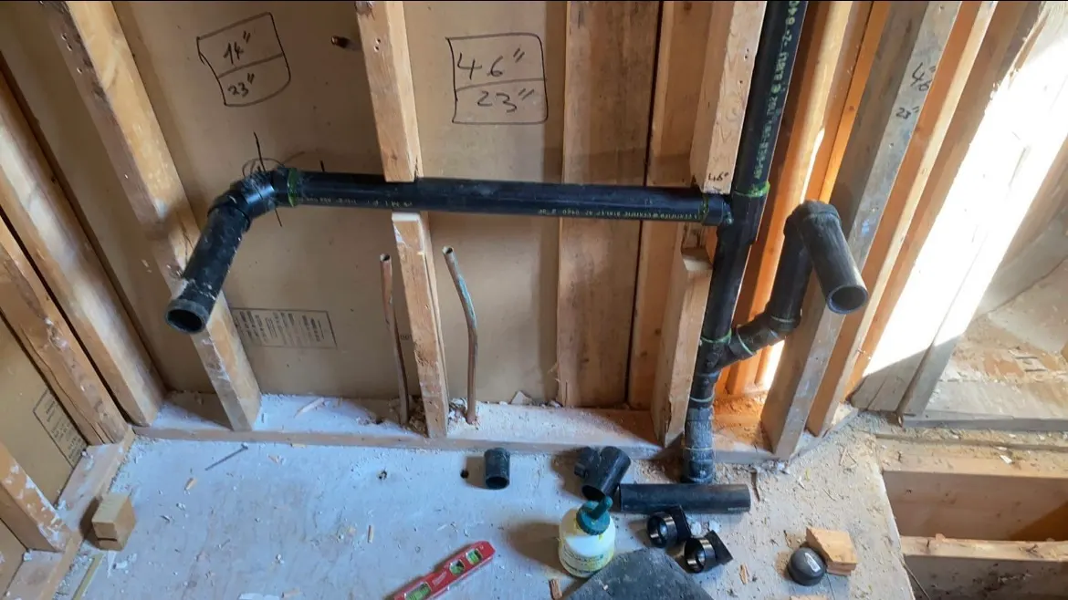 ABS drain and vent piping installed in an open stud wall, before the walls are closed.