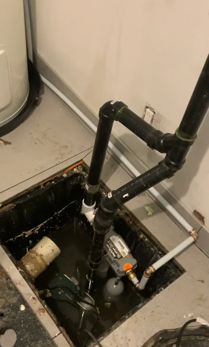 Sump pit with a submersible pump and a backup pump connected to the water supply, with ABS discharge piping.