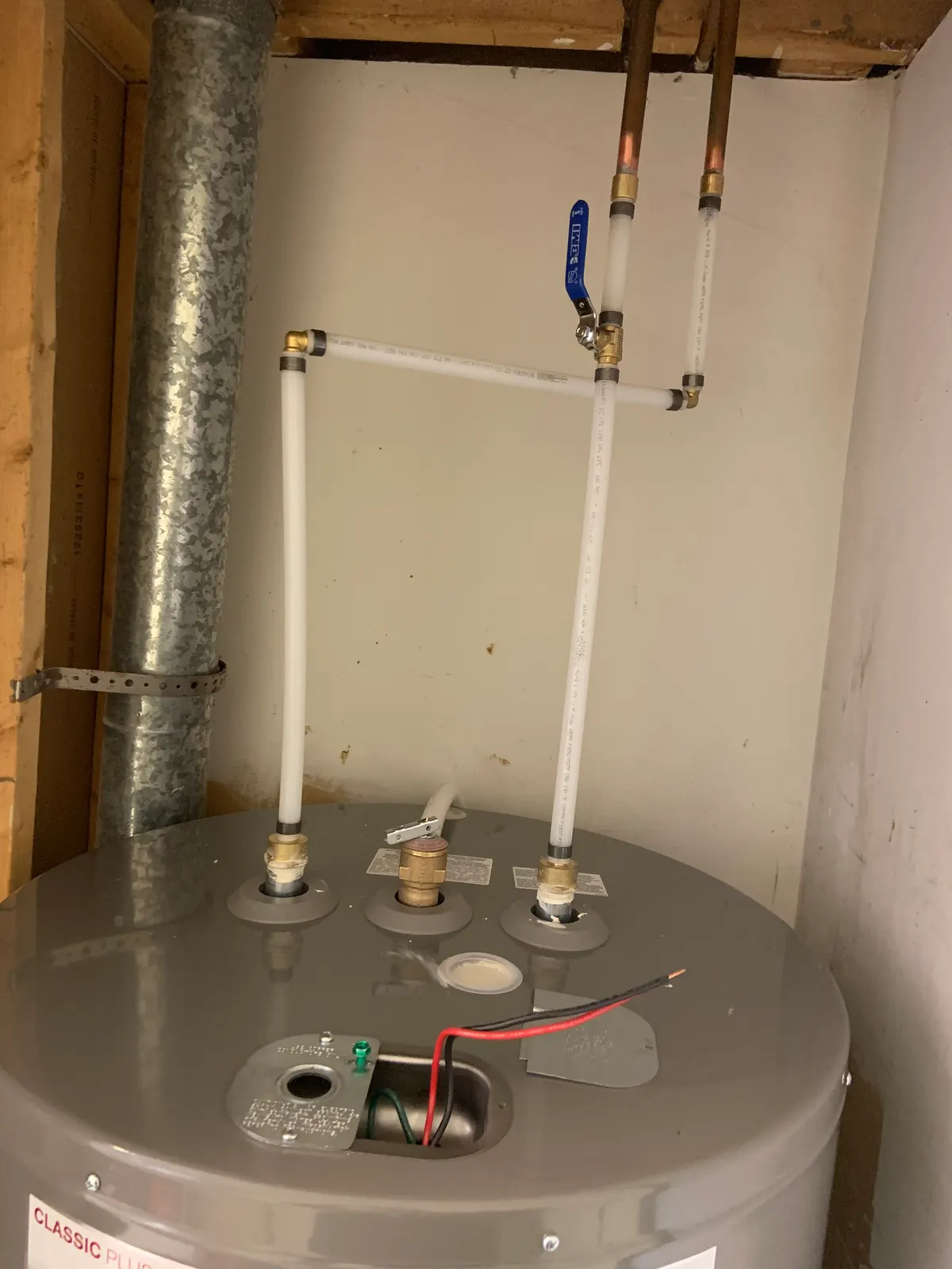 Electric water heater connected in PEX, with a ball-type shut-off valve on the supply.