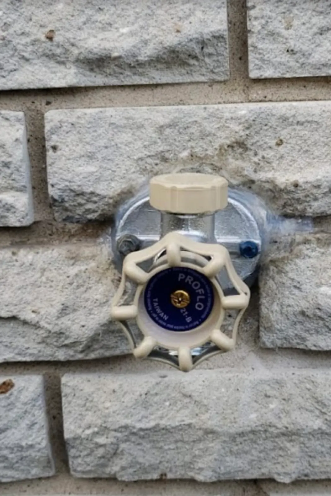 Frost-free outdoor faucet installed on a stone wall.